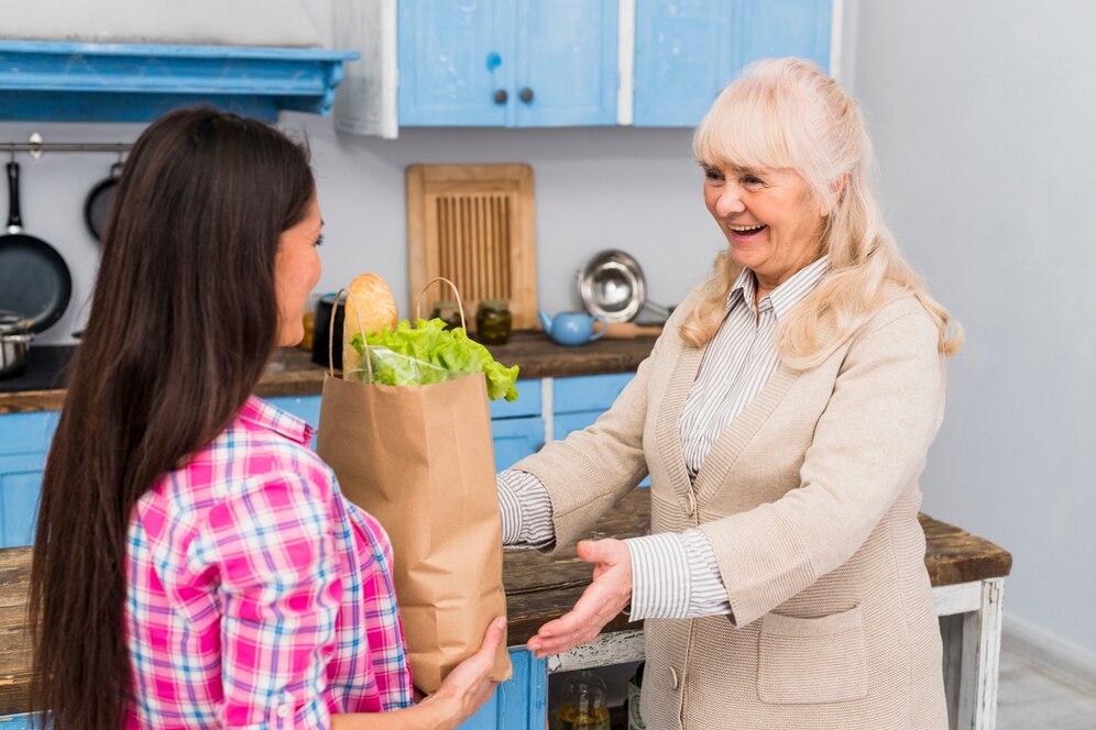 young-woman-giving-bag-groceries-her-senior-mother-kitchen_23-2148041478